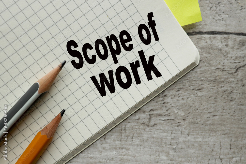 Poster scope of work notebook open on a wooden table. words