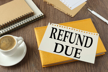 REFUND DUE beautiful yellow notepad on the work table. text on the page