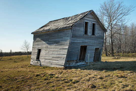 An Abandoned Wooden House Leaning To One Side; Manitoba, Canada