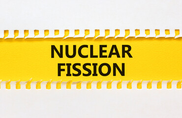 Nuclear fission symbol. Concept words Nuclear fission on beautiful yellow paper. Beautiful white...