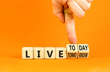 Live today not tomorrow symbol. Businessman turns wooden cubes and changes word Live tomorrow to...