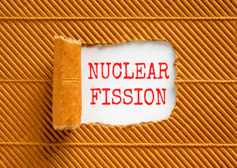 Nuclear fission symbol. Concept words Nuclear fission on beautiful white paper. Beautiful brown...