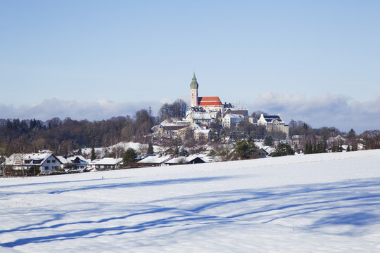 Snowy Field And Andechs Abbey In The Distance; Herrsching, Bavaria, Germany