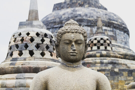Uncovered Buddha Statue Amidst The Latticed Stone Stupas Containing Buddha Statues On The Upper Terrace, Borobudur Temple Compounds, Central Java, Indonesia