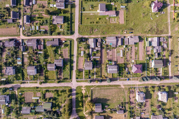 panoramic aerial view of eco village with wooden houses, gravel road, gardens and orchards