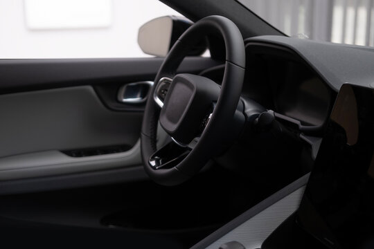 steering wheel electric car, Driver's column, modern passenger car, showcasing interior features such Control wheel, gear shift, front windshield and dashboard