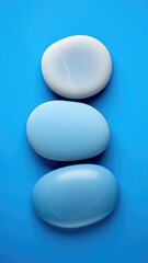 Three blue and white rocks on a blue surface