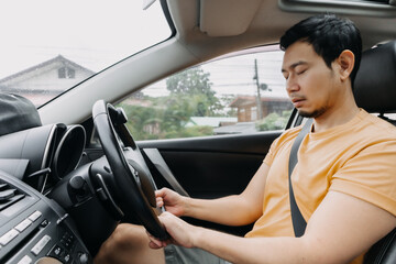 Asian man sleepy asleep while driving a car. - obrazy, fototapety, plakaty