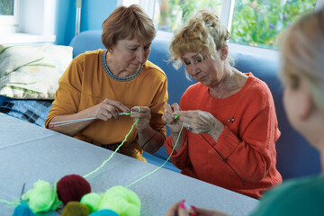 Senior women, knitting , friendship or old people, relaxing hobby in retirement. Elderly group, entertainment or hobby, retired friends and assisted living activity