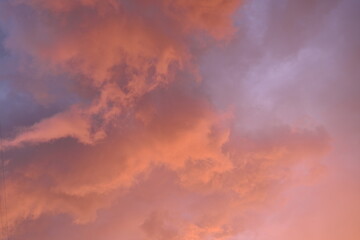 pink blue rainy clouds against the background of the winter sky illuminated by the rays of the sun,...
