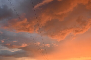 pink blue rainy clouds against the background of the winter sky illuminated by the rays of the sun, evening sunset, rays of the sun through cirrus pink clouds against the background of the sunset sky,