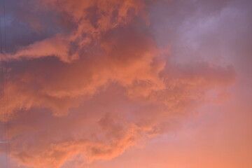 pink blue rainy clouds against the background of the winter sky illuminated by the rays of the sun,...