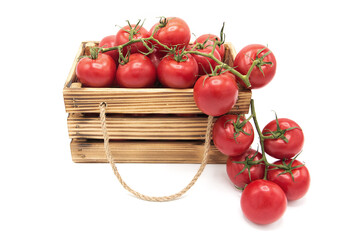 Wooden vintage box with organic ripe tomatoes isolated on a white background.