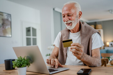 Fototapeta premium One senior man use laptop computer hold credit car shopping online
