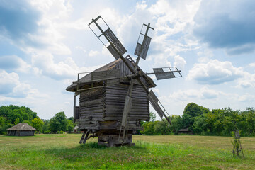 Fototapeta na wymiar Ancient wooden windmill in the field in Ukraine