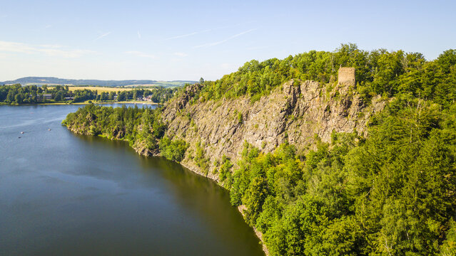 Aerial view of rock with castle ruins Oheb. Romantic medieval ruins over lake Sec. Czech republic, European union.