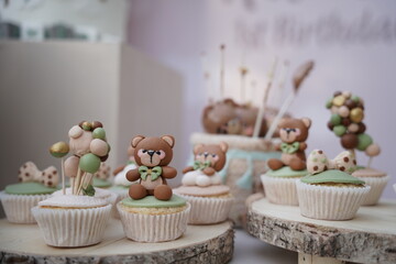Candy table: cupcakes, cookies, and desserts; themed decoration for teddy bear children's birthday...