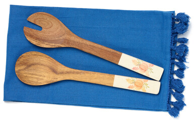 Two wooden spoons on a blue textile kitchen towel, top view