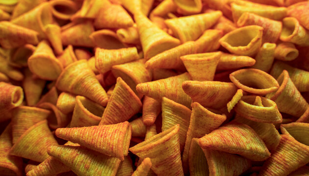Triangle plain corn cone snacks, Corn cone pile. Bugles chips, puffs with spices, crunchy puffed snack