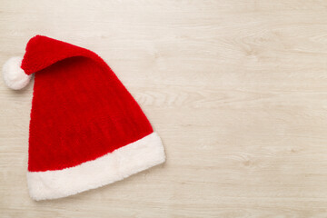 Obraz na płótnie Canvas Santa Claus red hat on wooden background, top, view