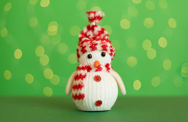 Fototapeta premium Cute snowman on table against blurred lights