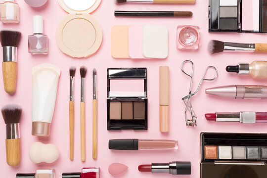 Flat lay with makeup products and tools on color background