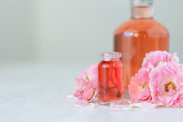 Concept of perfume with pure natural organic rose ingredient, essential oils. Glass bottles with...