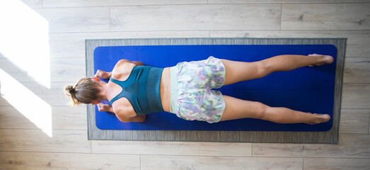 top view of woman doing yoga on mat