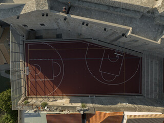 Drone topdown shot of a basketball court in old town, surrounded by castle walls, Dubrovnik, Croatia