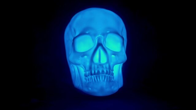 Human Skull glowing multi colored lights in the dark. 4k horror or Halloween asset