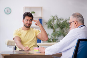 Young male patient visiting old male doctor