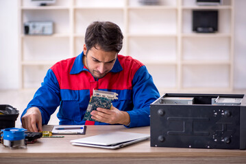 Fototapeta na wymiar Young male repairman repairing computer