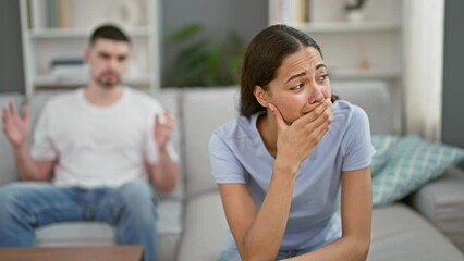 Distressed beautiful couple arguing and crying on the relaxed sofa at home, their love stressed and strained - Powered by Adobe