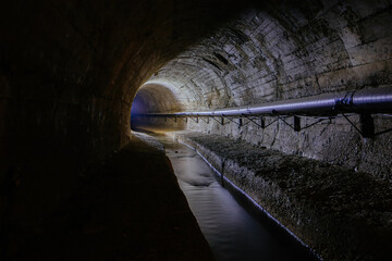Underground vaulted urban sewer tunnel with dirty sewage