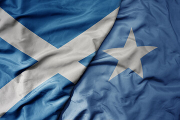 big waving national colorful flag of scotland and national flag of somalia .