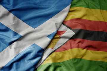 big waving national colorful flag of scotland and national flag of zimbabwe .