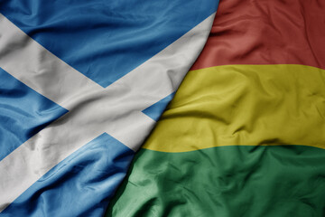 big waving national colorful flag of scotland and national flag of bolivia .