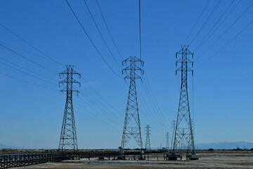 Three electrical transmission towers adjacent to San Francisco Bay