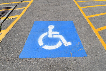 ADA parking symbol and yellow crosshatch. This allow persons with disabilities exit space on both...