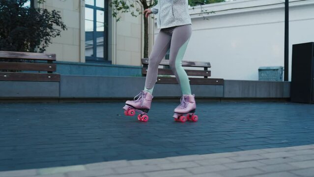 Tracking shot of young woman riding quad rollers skates in city