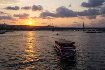 Fototapeta premium Tourist boat in front of Istanbul cityscape on sunset