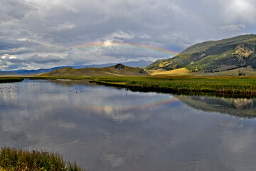 Faint rainbow reflection in Flat Creek, Wyoming. The slow moving tributary of the Snake River moves through cattails near Jackson, Wyoming 