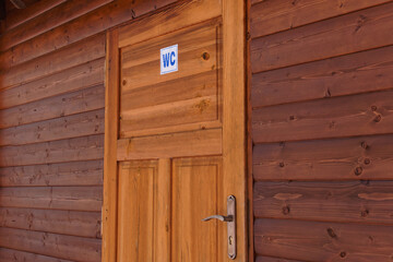Napis WC na drewnianych drzwiach. - obrazy, fototapety, plakaty
