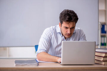 Young male teacher in front of white board