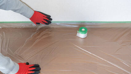 養生資材・a protective coating｜マスカーで床を保護する作業員 - obrazy, fototapety, plakaty