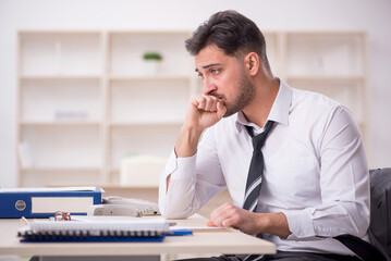 Naklejka premium Young male employee working in the office