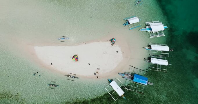 Drone view of boats on coastline of sandbar, turquoise water and colar reefs. Barobo, Surigao del Sur. Philippines.