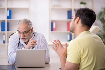 Young male patient visiting old male doctor