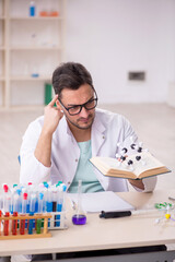 Young male chemist sitting at the lab