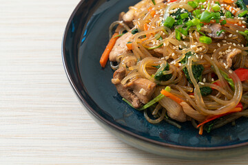 japchae or stir-fried Korean vermicelli noodles with vegetables and pork topped with white sesame